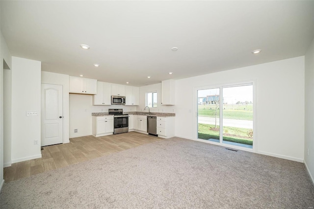 kitchen featuring light hardwood / wood-style flooring, white cabinets, and appliances with stainless steel finishes