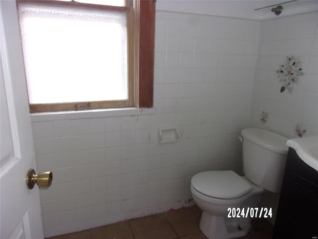 bathroom with vanity, tile patterned flooring, toilet, and tile walls