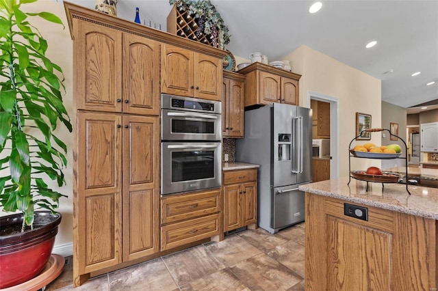 kitchen with appliances with stainless steel finishes, light stone countertops, and light tile patterned floors