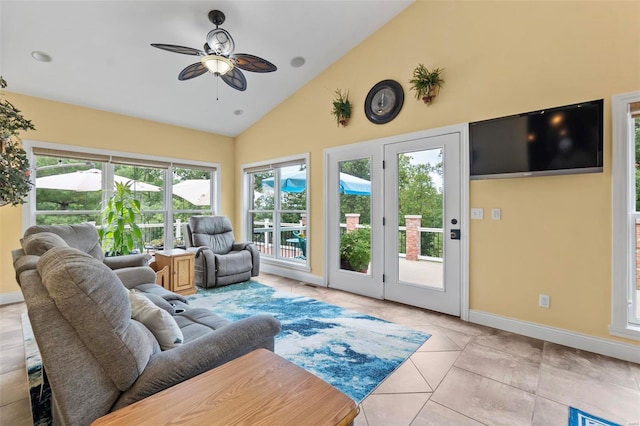 tiled living room with high vaulted ceiling, ceiling fan, and plenty of natural light