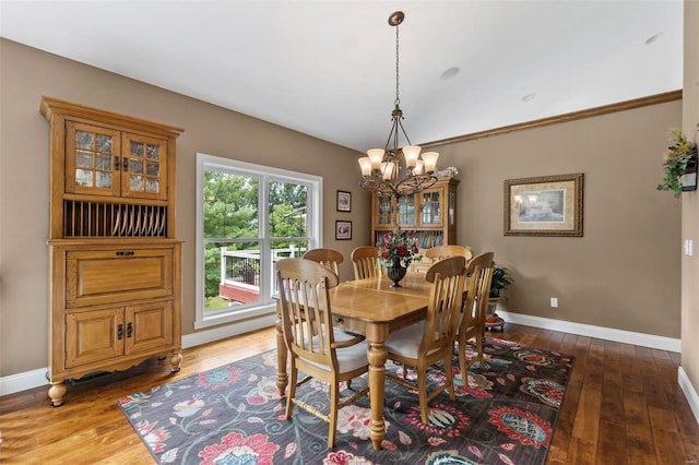 dining room featuring crown molding, wood-type flooring, and a notable chandelier