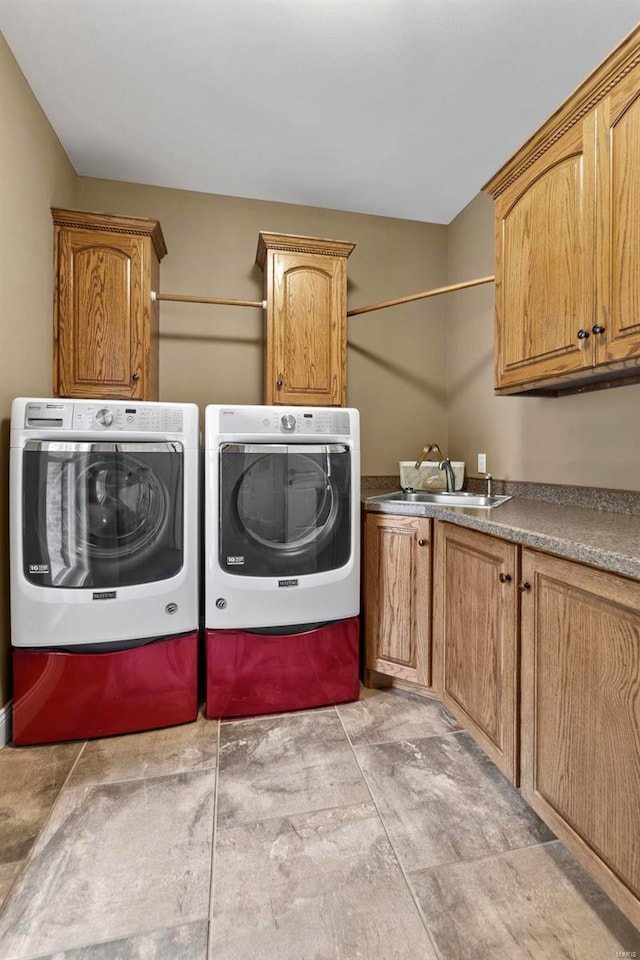 laundry room with sink, cabinets, washer and clothes dryer, and light tile patterned floors