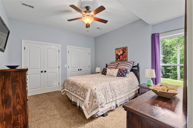 bedroom with multiple closets, carpet, and ceiling fan