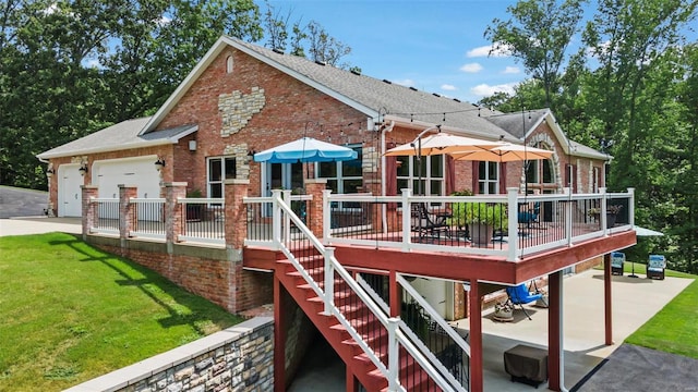 rear view of house with a garage, a wooden deck, and a lawn