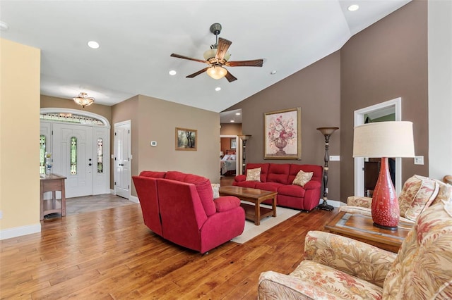 living room featuring light hardwood / wood-style flooring, high vaulted ceiling, and ceiling fan