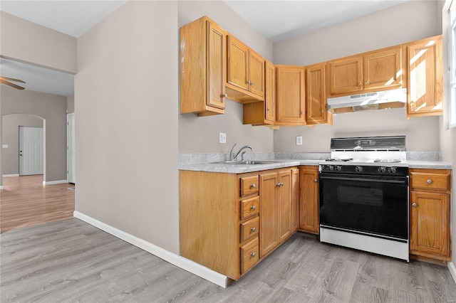 kitchen with sink, light hardwood / wood-style flooring, ceiling fan, and white gas range