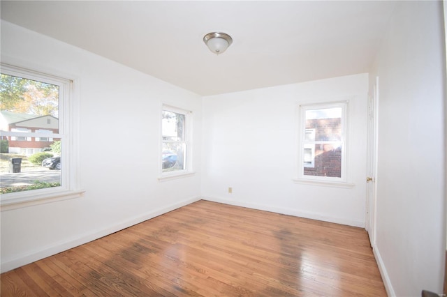 empty room with hardwood / wood-style floors and plenty of natural light