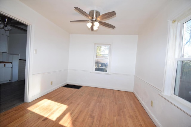 unfurnished room featuring a wealth of natural light, light hardwood / wood-style floors, and ceiling fan