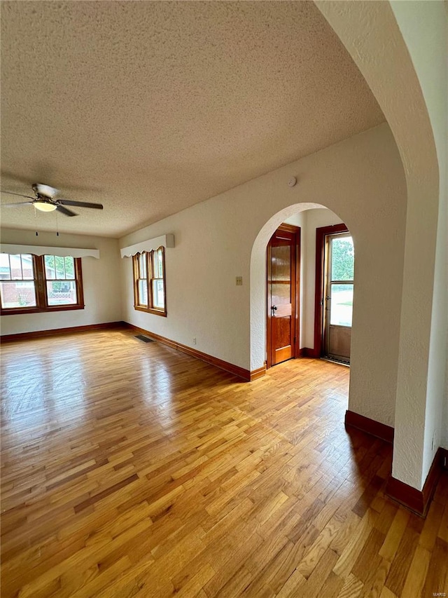 spare room featuring ceiling fan, a textured ceiling, and light hardwood / wood-style flooring