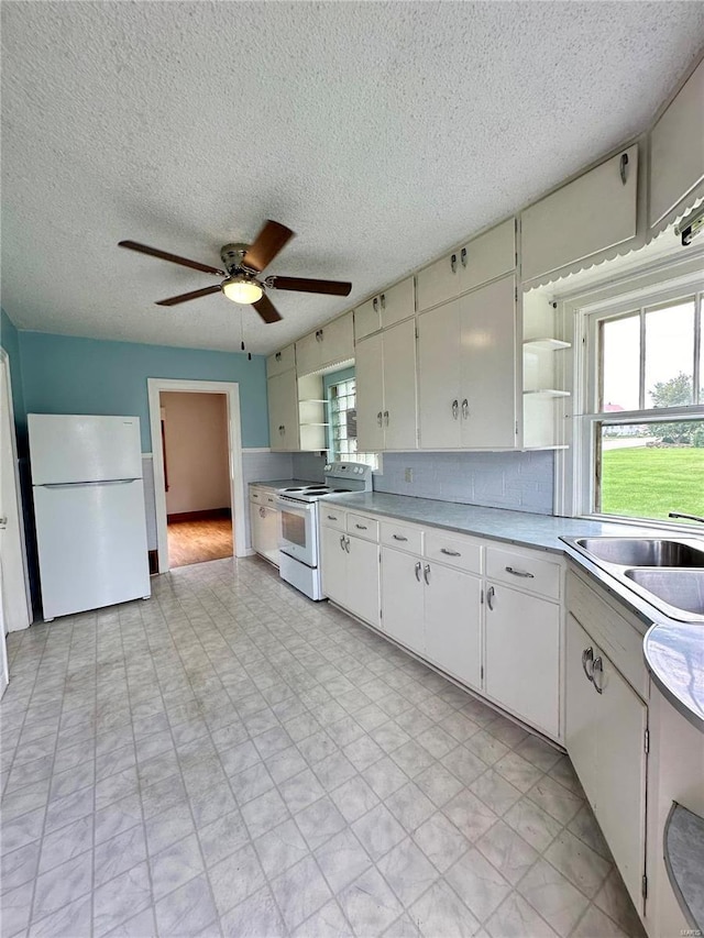 kitchen with white appliances, white cabinets, light countertops, decorative backsplash, and open shelves