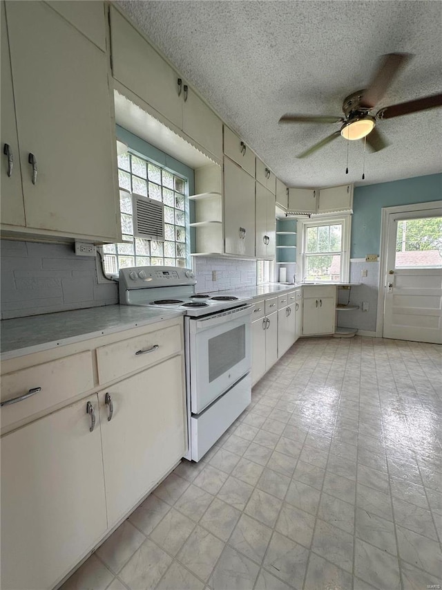 kitchen featuring white range with electric stovetop, open shelves, light countertops, backsplash, and white cabinets