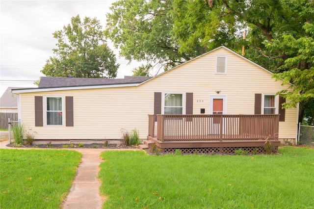 rear view of house featuring a yard and a deck