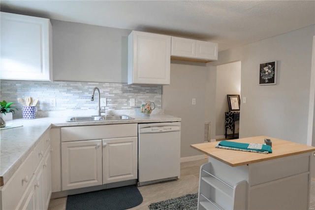 kitchen with tasteful backsplash, sink, dishwasher, and white cabinetry