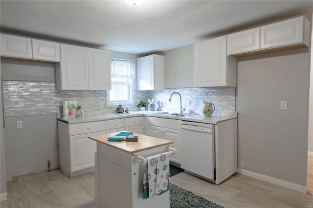 kitchen with white cabinets, white dishwasher, and sink