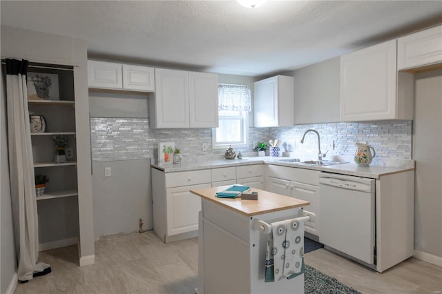 kitchen with white cabinets, sink, white dishwasher, and a center island