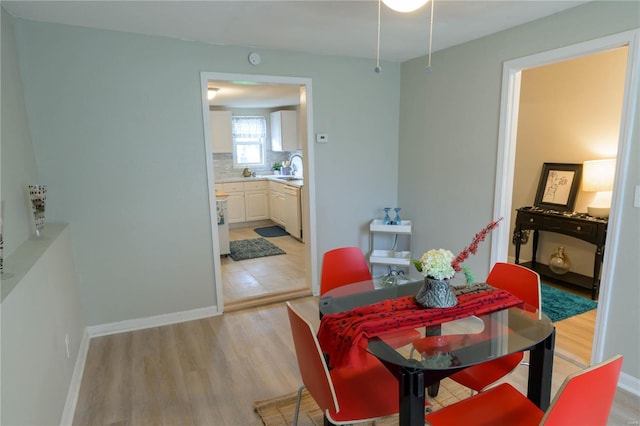 dining space featuring sink and light wood-type flooring