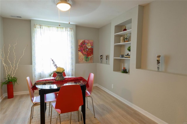 dining space with built in features and light wood-type flooring