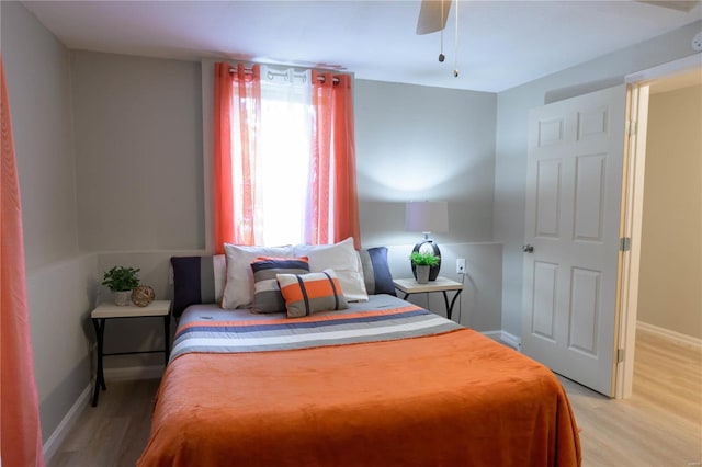 bedroom featuring ceiling fan, multiple windows, and hardwood / wood-style flooring