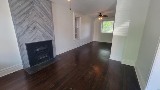 unfurnished living room featuring ceiling fan, a fireplace, and dark wood-type flooring