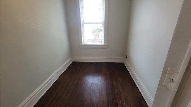 unfurnished room with dark wood-type flooring