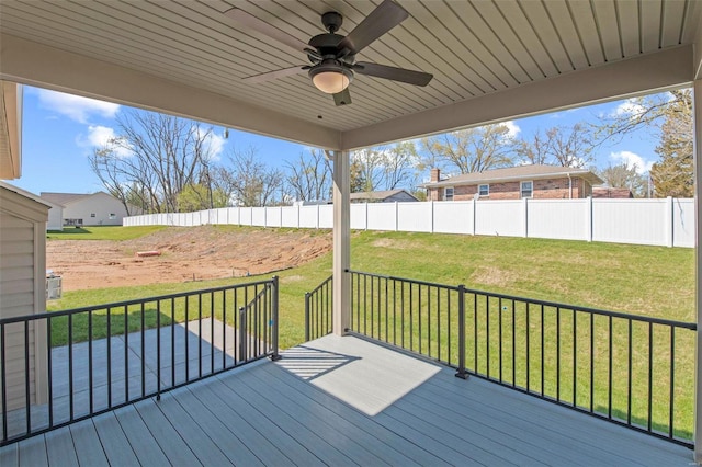 wooden terrace featuring a lawn and ceiling fan