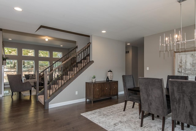 dining room with dark wood-type flooring and an inviting chandelier