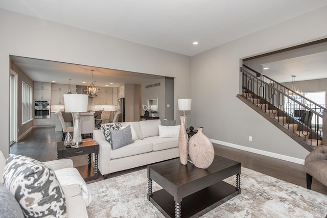 living room with a chandelier and dark hardwood / wood-style flooring