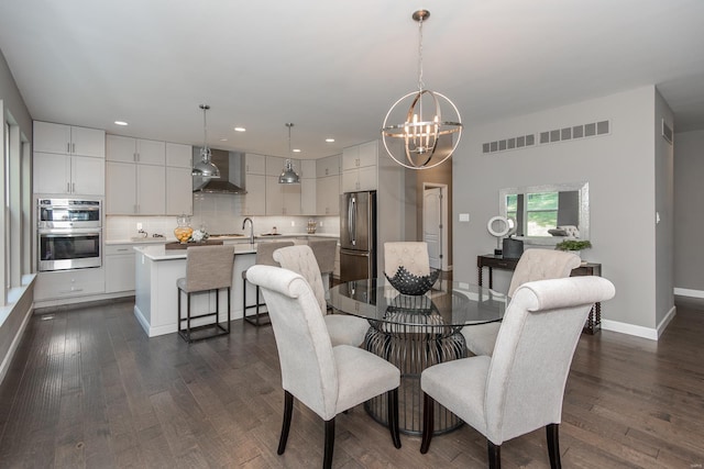 dining area with sink, a chandelier, and dark hardwood / wood-style floors