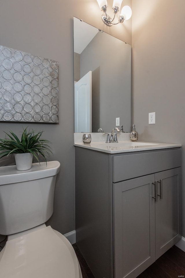 bathroom with vanity, toilet, and hardwood / wood-style floors