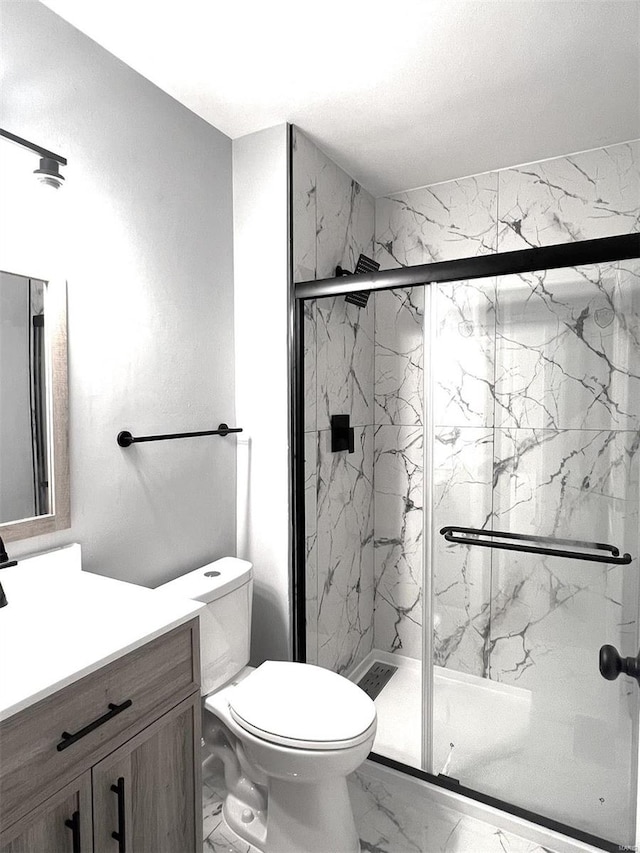 bathroom featuring tile patterned floors, toilet, vanity, and an enclosed shower