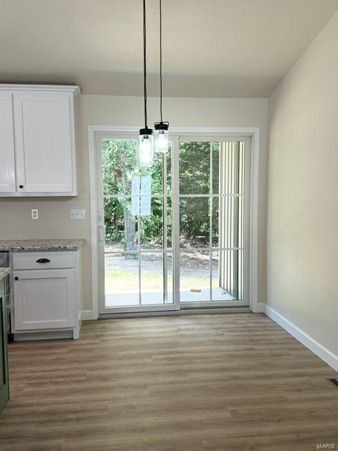 unfurnished dining area featuring a chandelier and hardwood / wood-style floors