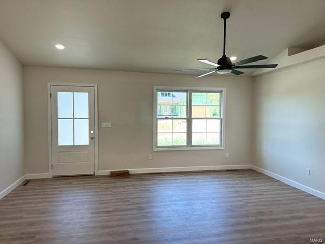 interior space with ceiling fan and wood-type flooring