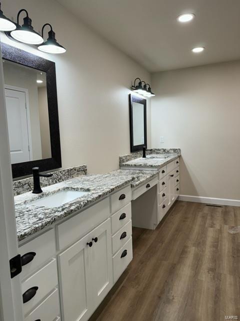 bathroom with recessed lighting, wood finished floors, vanity, and baseboards