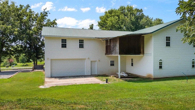 back of property featuring a garage and a lawn