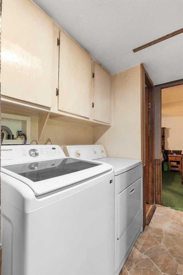 clothes washing area featuring light carpet, cabinets, and independent washer and dryer