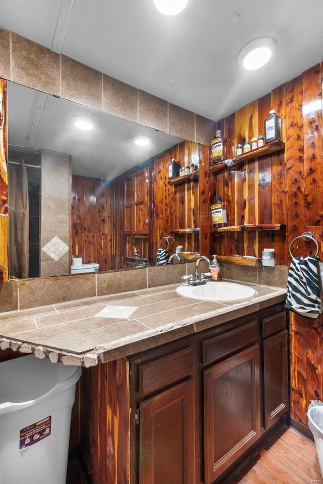 bathroom with wood walls and vanity