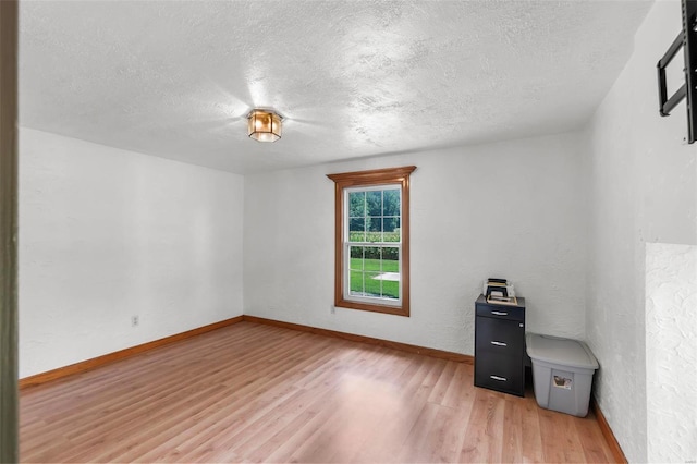 unfurnished office featuring hardwood / wood-style floors and a textured ceiling