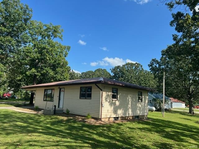 rear view of property featuring a yard