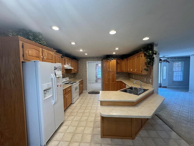 kitchen featuring white appliances, sink, kitchen peninsula, and a healthy amount of sunlight