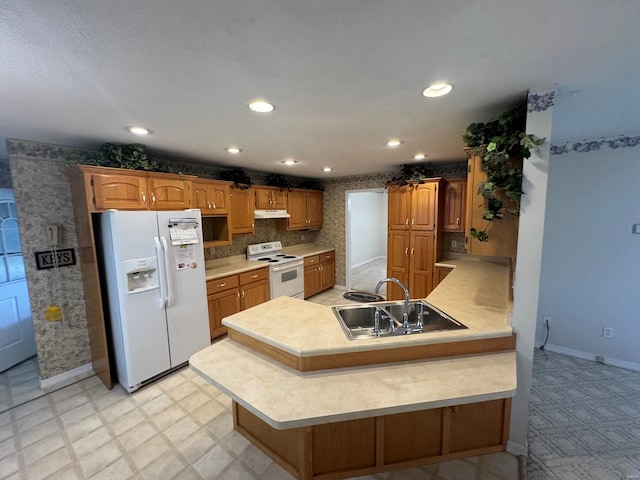 kitchen with white appliances, sink, and kitchen peninsula