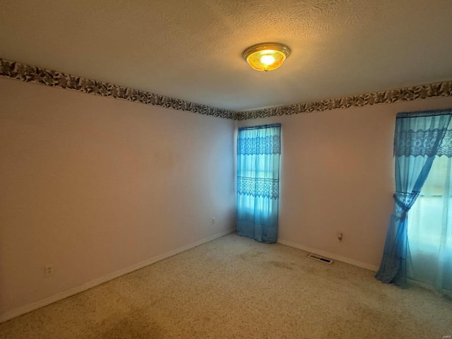 carpeted spare room featuring a textured ceiling