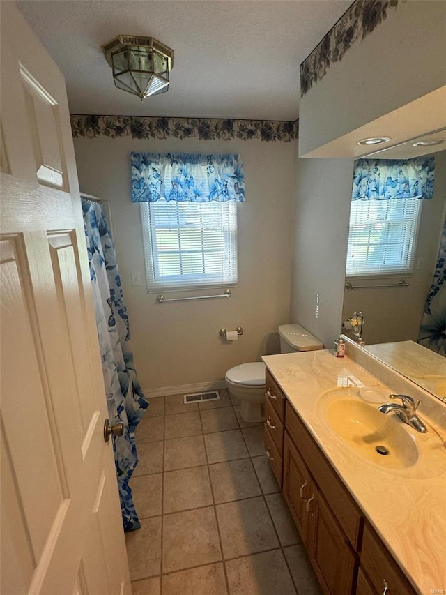 bathroom featuring tile patterned floors, vanity, toilet, and a wealth of natural light