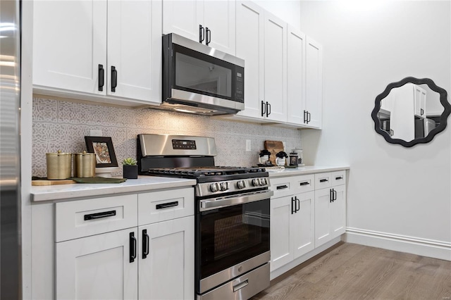 kitchen with white cabinets, stainless steel appliances, and backsplash