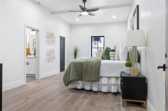 bedroom with wood-type flooring, connected bathroom, and ceiling fan