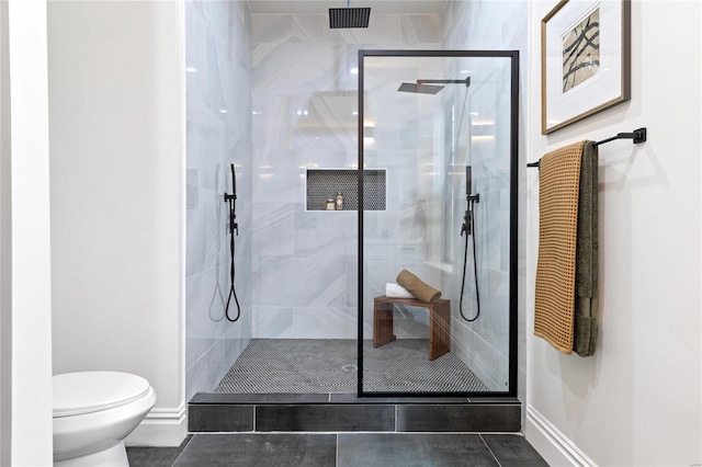 bathroom featuring toilet, tile patterned floors, and a shower with door