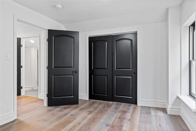 unfurnished bedroom with light hardwood / wood-style floors and a closet