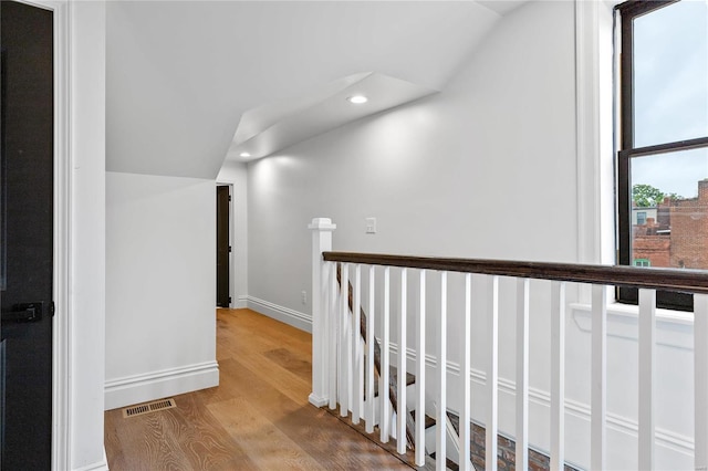 hall featuring hardwood / wood-style flooring and lofted ceiling