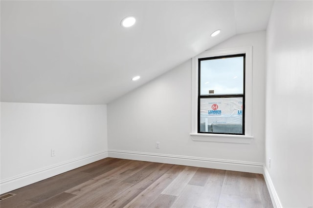 additional living space featuring vaulted ceiling and hardwood / wood-style floors