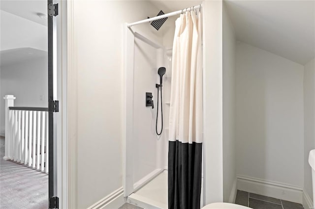 bathroom with lofted ceiling, a shower with curtain, and tile patterned flooring