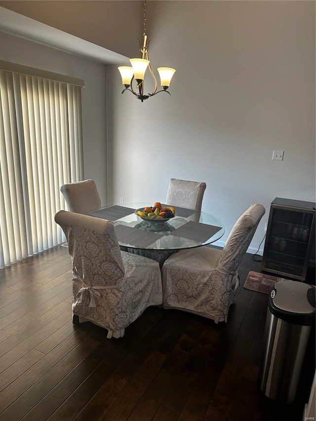 dining space with dark hardwood / wood-style flooring and an inviting chandelier